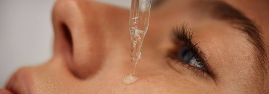 Mulher aplicando sérum de vitamina c facial em sua pele como parte de uma rotina de cuidados